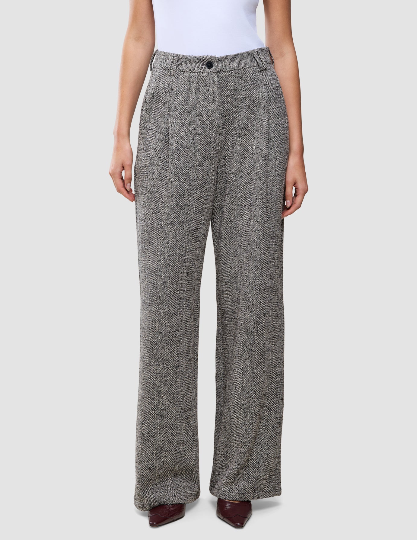 Damenhose Ashryn Wide Domino Herringbone: eine hoch taillierte Hose mit weitem Bein aus schwarz-weißem Bouclé mit Fischgrätenmuster.