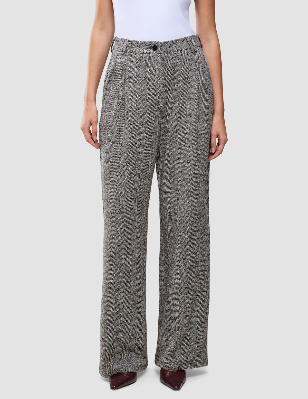 Damenhose Ashryn Wide Domino Herringbone: eine hoch taillierte Hose mit weitem Bein aus schwarz-weißem Bouclé mit Fischgrätenmuster.