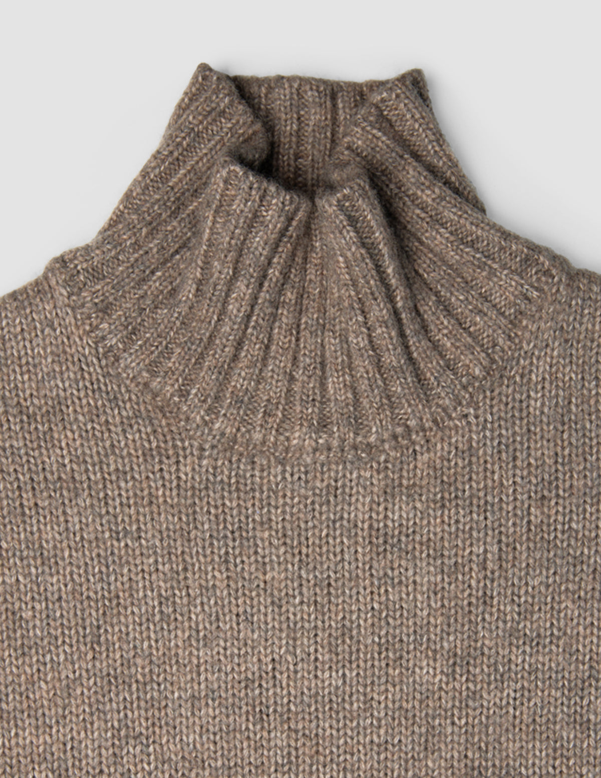 Damen-Rollkragenpullover aus grobem, weichem Wollstrick in Taupe-Melange mit gerippter Struktur.