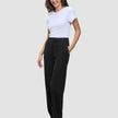 Eine Frau, die ein weißes T-Shirt und eine Women GO2 Pants Straight Black in einem schlichten, skandinavischen Design trägt.