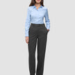 Eine Frau, die ein hellblaues Hemd mit Knöpfen und eine Women GO2 Pants Straight in Dunkelgrau-Melange trägt, die sich durch ein schlichtes, skandinavisches Design auszeichnet.