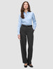 Eine Frau trägt ein hellblaues Hemd, das in eine Women GO2 Pants Straight Dark Grey Melange gesteckt ist, dazu einen schwarzen Gürtel – ein Beispiel für klares skandinavisches Design.