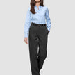 Eine Frau in einem hellblauen Hemd mit Knöpfen und einem schwarzen Gürtel trägt die Women GO2 Pants Straight Dark Grey Melange und präsentiert damit einen minimalistischen Look, der vom skandinavischen Design inspiriert ist.