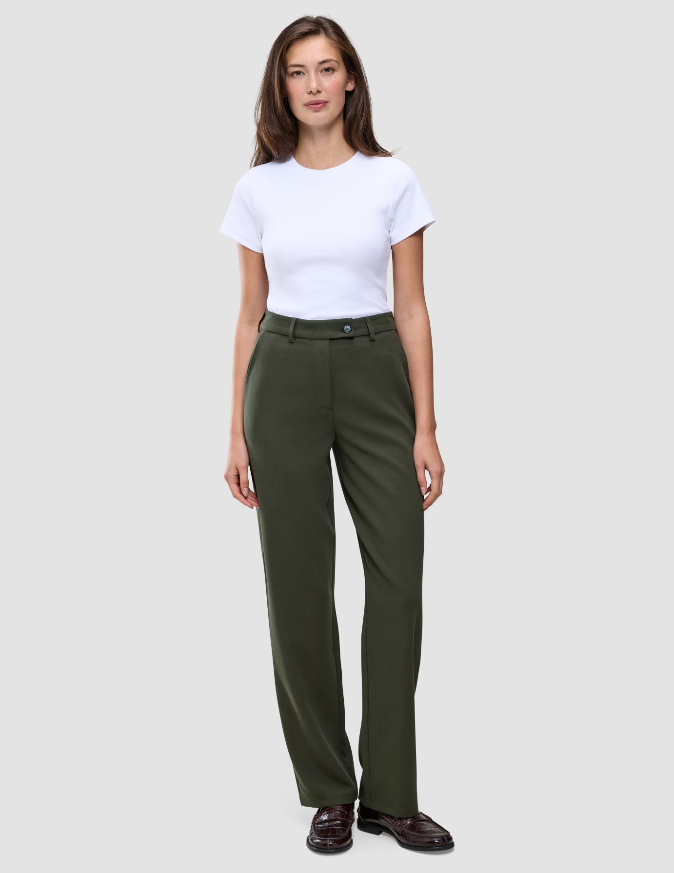 Eine Person, die ein weißes T-Shirt und eine Women GO2 Pants Straight Dusty Olive mit geradem Bein trägt.