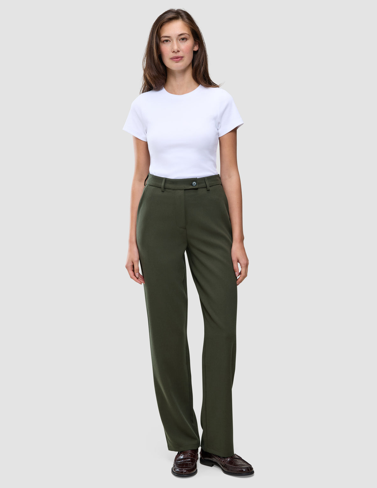Eine Person, die ein weißes T-Shirt und eine Women GO2 Pants Straight Dusty Olive mit geradem Bein trägt.