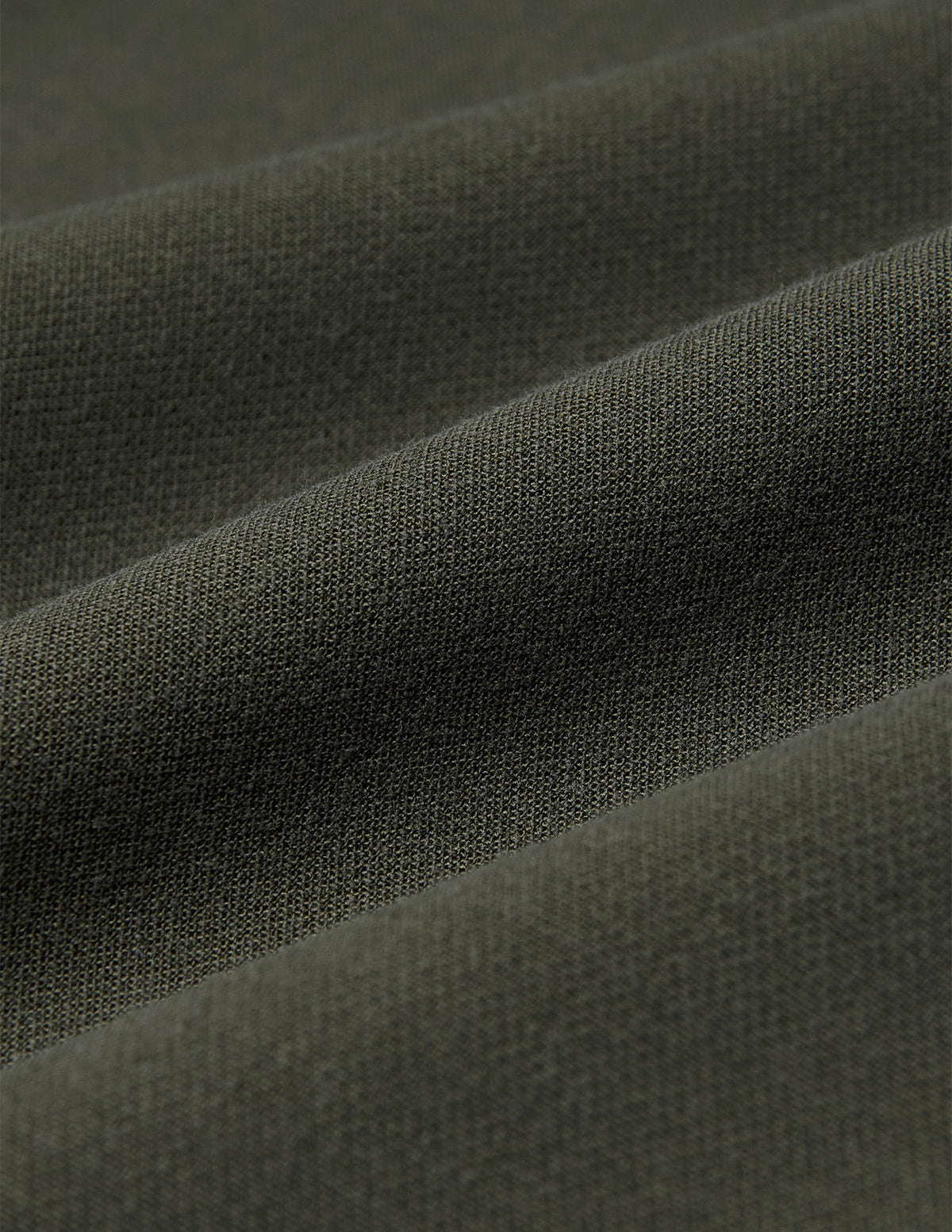 Nahaufnahme der Women GO2 Pants Straight Dusty Olive aus olivgrünem Doubleface-Stoff mit den für skandinavisches Design charakteristischen diagonalen Falten.