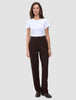 Eine Person, die ein weißes T-Shirt und die Hose Women GO2 Pants Straight Mocha in Dunkelbraun trägt, die sich durch ein schlichtes, skandinavisches Design auszeichnet.