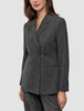 Eine Person, die einen Women Nara Blazer Fitted Black Check trägt, einen taillierten Zweireiher-Blazer mit dunkelgrauem Mikrokaromuster und 360°-Stretch.