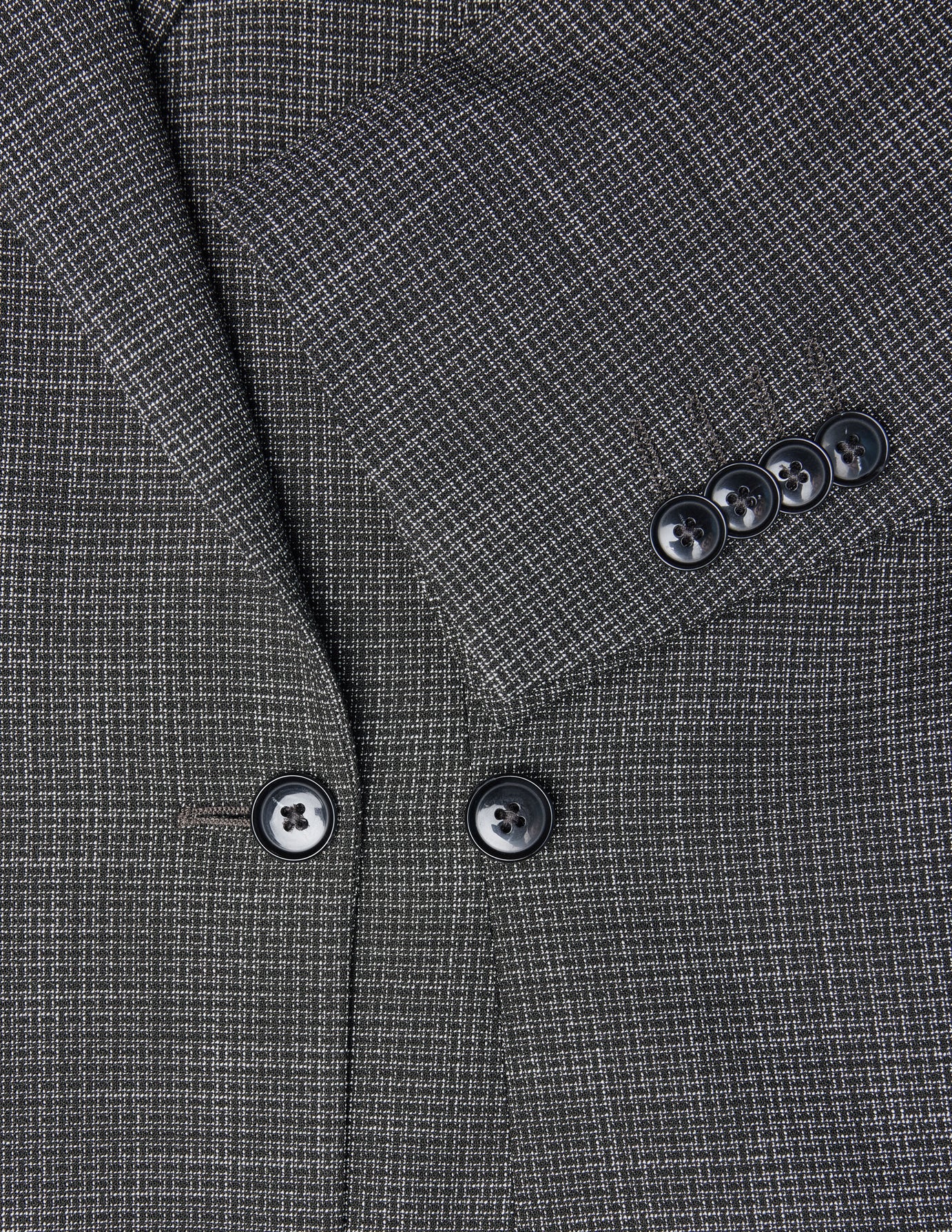 Nahaufnahme eines schwarzen, karierten Women Nara-Blazers in taillierter Passform, die das Revers, die Knöpfe auf der Vorderseite und eine Ärmelbündchen mit vier Knöpfen zeigt.