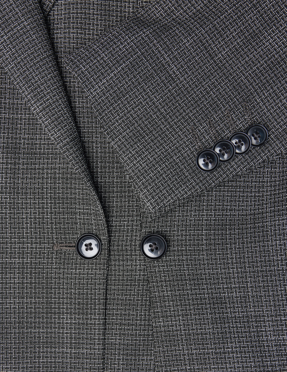 Nahaufnahme eines schwarzen, karierten Women Nara-Blazers in taillierter Passform, die das Revers, die Knöpfe auf der Vorderseite und eine Ärmelbündchen mit vier Knöpfen zeigt.