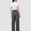 Eine Frau, von hinten gesehen, die ein weißes T-Shirt und eine graue Women Nara Pants Wide Black Check mit dezentem Gittermuster und hoher Taille trägt.