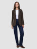 Eine Frau, die einen Women Serene Blazer Regular Walnut Herringbone, ein weißes T-Shirt, dunkelblaue Jeans und braune Stiefel mit Absatz trägt.