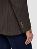 Nahaufnahme eines Women Serene-Blazers in der Passform Regular in der Farbe Walnut mit Fischgrätenmuster am Ärmel, brauner Fischgrätenstruktur in Wolloptik, drei Knöpfen an den Manschetten und einem goldenen Armreif am Handgelenk.