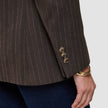 Nahaufnahme eines Women Serene-Blazers in der Passform Regular in der Farbe Walnut mit Fischgrätenmuster am Ärmel, brauner Fischgrätenstruktur in Wolloptik, drei Knöpfen an den Manschetten und einem goldenen Armreif am Handgelenk.
