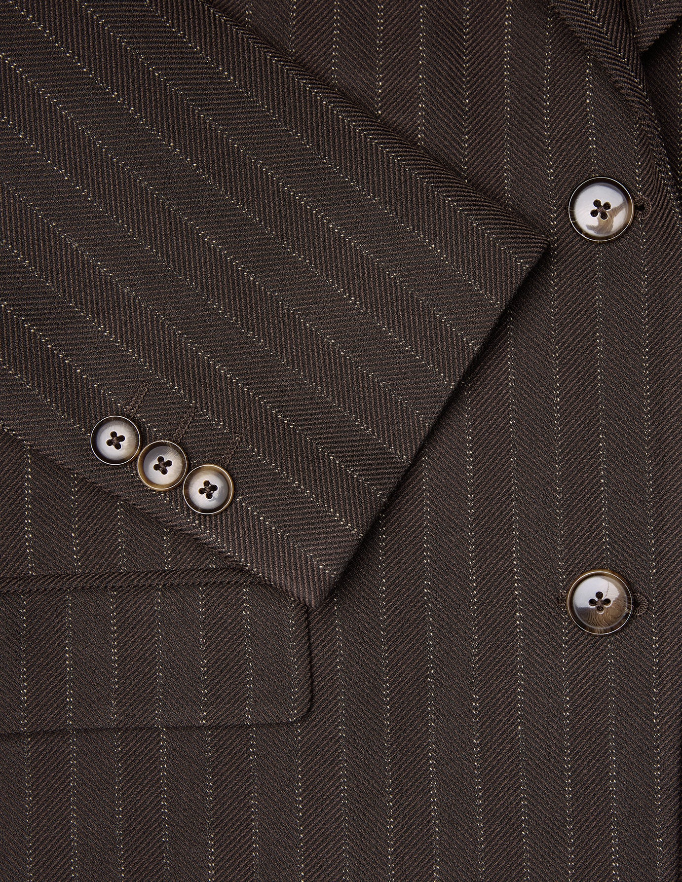 Nahaufnahme eines Women Serene-Blazers in der regulären Passform mit Walnuss-Fischgrätenmuster an den Ärmeln, zu sehen sind drei Knöpfe und passende Knöpfe an der Vorderseite.