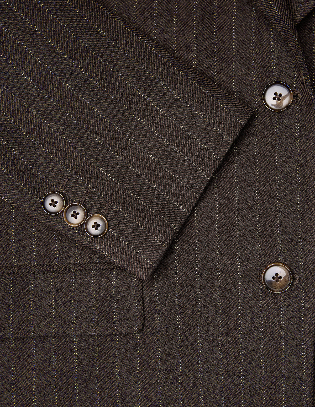 Nahaufnahme eines Women Serene-Blazers in der regulären Passform mit Walnuss-Fischgrätenmuster an den Ärmeln, zu sehen sind drei Knöpfe und passende Knöpfe an der Vorderseite.