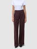 Damenhose Serene Wide Berry Pinstripe in dunklem Beerenrot mit hoher Taille, weitem Bein und vertikalen Nadelstreifen, kombiniert mit einem weißen T-Shirt für einen Hauch von skandinavischem Design.