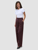 Eine Frau trägt ein weißes T-Shirt und die Women Serene Pants Wide Berry Pinstripe – eine hoch taillierte, weit geschnittene Hose in Beerenfarbe mit Nadelstreifen im skandinavischen Design.