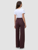 Rückansicht einer Person, die eine hoch taillierte, weit geschnittene Women Serene Pants Wide Berry Pinstripe trägt, kombiniert mit einem weißen T-Shirt, das skandinavisches Design verkörpert.