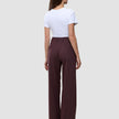 Rückansicht einer Person, die eine hoch taillierte, weit geschnittene Women Serene Pants Wide Berry Pinstripe trägt, kombiniert mit einem weißen T-Shirt, das skandinavisches Design verkörpert.