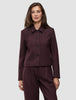 Eine Frau trägt die Women Serene Short Jacket Berry Pinstripe – eine Jacke aus dunkelviolettem Stoff mit Nadelstreifen, die sich durch eine kastenförmige Passform und eine kurze Silhouette auszeichnet.