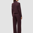 Eine Person, von hinten gesehen, trägt die kurze Damenjacke Serene in der Farbe Berry Pinstripe mit kastenförmiger Passform sowie eine dazu passende Hose mit weitem Bein im skandinavischen Stil.