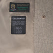 Innenetiketten des Damen-Wollmantels in Greige mit den Markenlogos von Manteco und Italian Wool sowie Pflegehinweisen, wie sie für skandinavisches Design typisch sind.